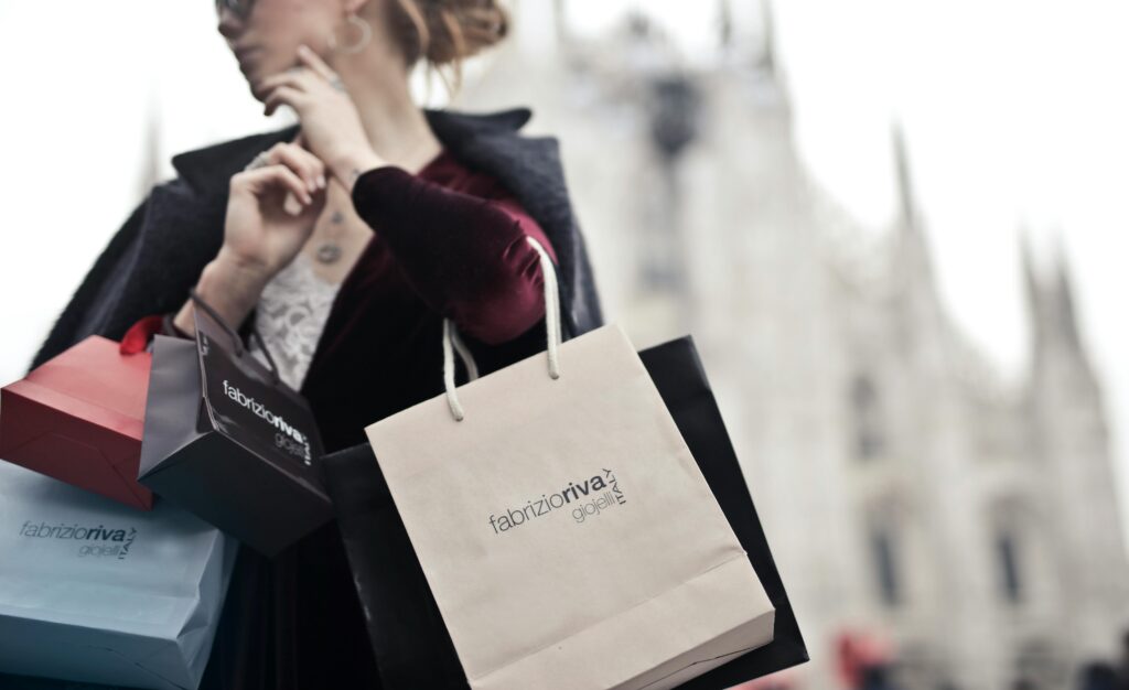 pexels-photo-972887-972887 Stylish woman holding designer shopping bags near Milan's iconic Duomo. Urban fashion and lifestyle concept.